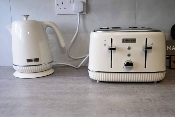 A kitchen with a white kettle and a white toaster on a countertop.