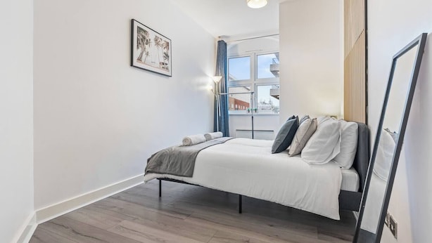Une chambre à coucher avec un lit, une fenêtre et un tableau au mur.