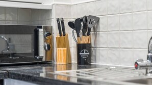 Un plan de travail de cuisine avec un four à micro-ondes, un bloc à couteaux et un porte-ustensiles.