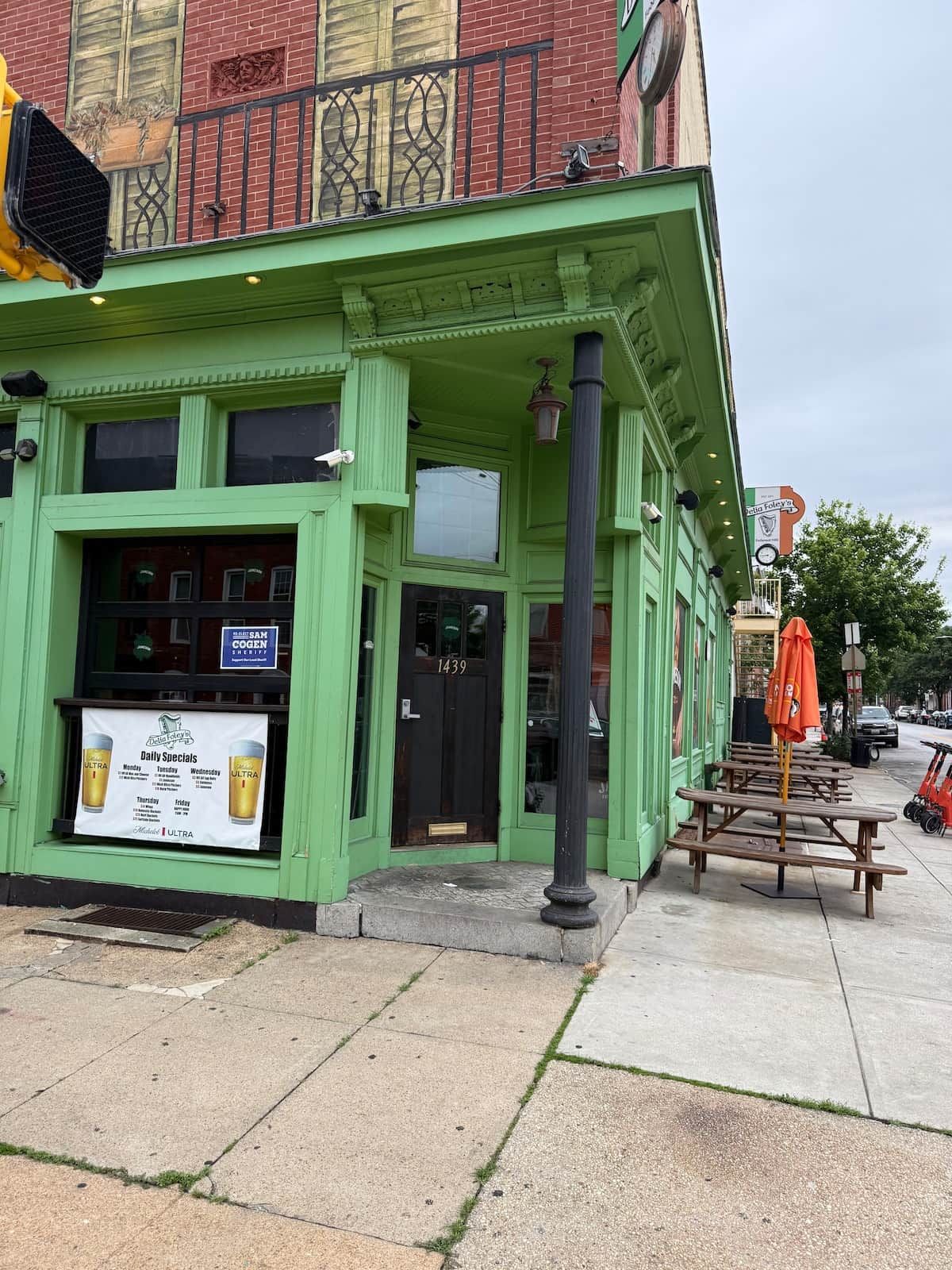 A green building with a storefront, a door labeled '1439', and a sign for 'Daily Specials'.