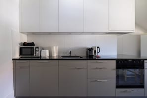 Una cocina moderna con microondas, tostadora, hervidor y horno.