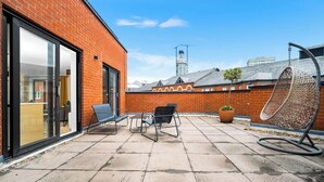 A patio with outdoor seating, a hanging chair, and a potted plant. - #116 Modern 2 bed - 10 mins from Bullring & Grand Central (West Midlands)