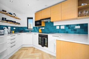 A modern kitchen with white cabinets, a microwave, and a dishwasher. - #116 Modern 2 bed - 10 mins from Bullring & Grand Central (West Midlands)