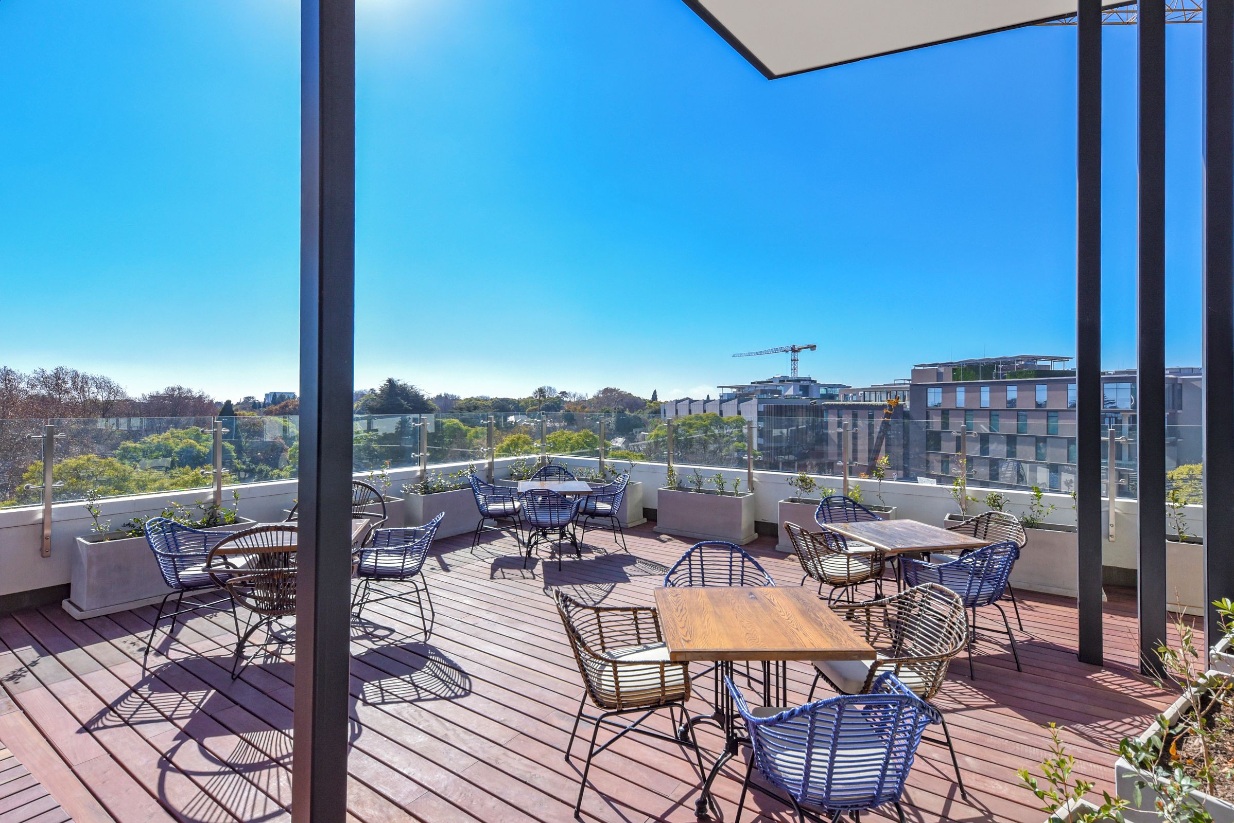 Una terraza en la azotea con mobiliario exterior y vistas a la ciudad.