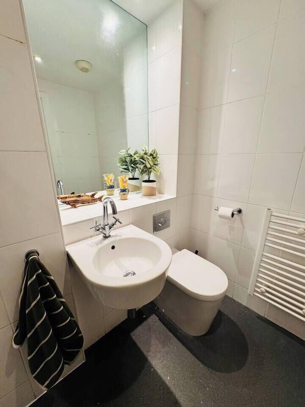 A bathroom with a white sink, a toilet, and a towel rack. - #12 CozyCanalsideLoft|near CoventryCathedral|for 6 (West Midlands)