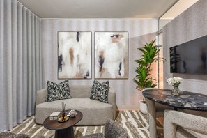 A modern living room with a sofa, coffee table, and artwork on the wall. - One Rosebank | Modern Comfort | Heart of the City (Johannesburg)