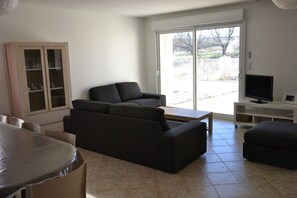 Ein Wohnzimmer mit einer Couch, einem Fernseher und einem Schrank.