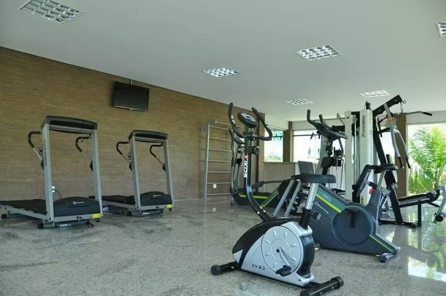 A gym with treadmills, elliptical machines, and a stationary bike.