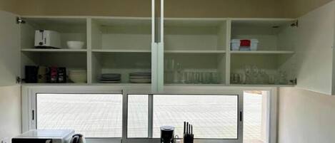 A kitchen with a microwave, toaster, sink, and cabinets.
