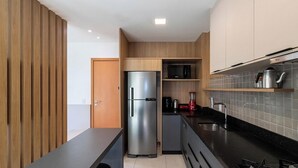 A modern kitchen with a built-in refrigerator, microwave, and coffee maker. - Cozy Apartment in Condominium With Pool Avr0503 (Penha)
