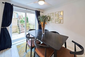 A dining area with a table, chairs, a vase with flowers, and a view of the outside. - #112 Blueberry cottage Cornwall 4 bed 4 bathroom (Cornwall)
