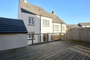 Ein Wohnhaus mit einer Holzdiele und einem Holzzaun.
