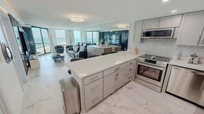 A modern kitchen with a central island, stainless steel appliances, and a view to the outside. - Sundestin 1014 - Beautiful remodeled 1 BR sleeps 4 (Destin)
