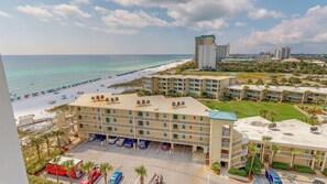 Un hôtel à plusieurs étages, doté d’un parking et offrant une vue sur la plage.