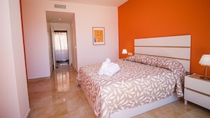 A hotel room with a bed, a nightstand, a lamp, and a framed picture on the wall. - Coto Real apartment Zira 321 (Manilva)
