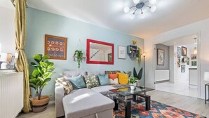 Uma sala de estar moderna com um sofá, mesa de centro e um tapete colorido.