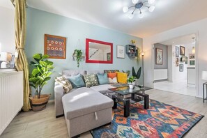 A modern living room with a sofa, coffee table, and a colorful rug. - #126 Cosy 5 mins to Coventry Cathedral | sleeps 7 (West Midlands)