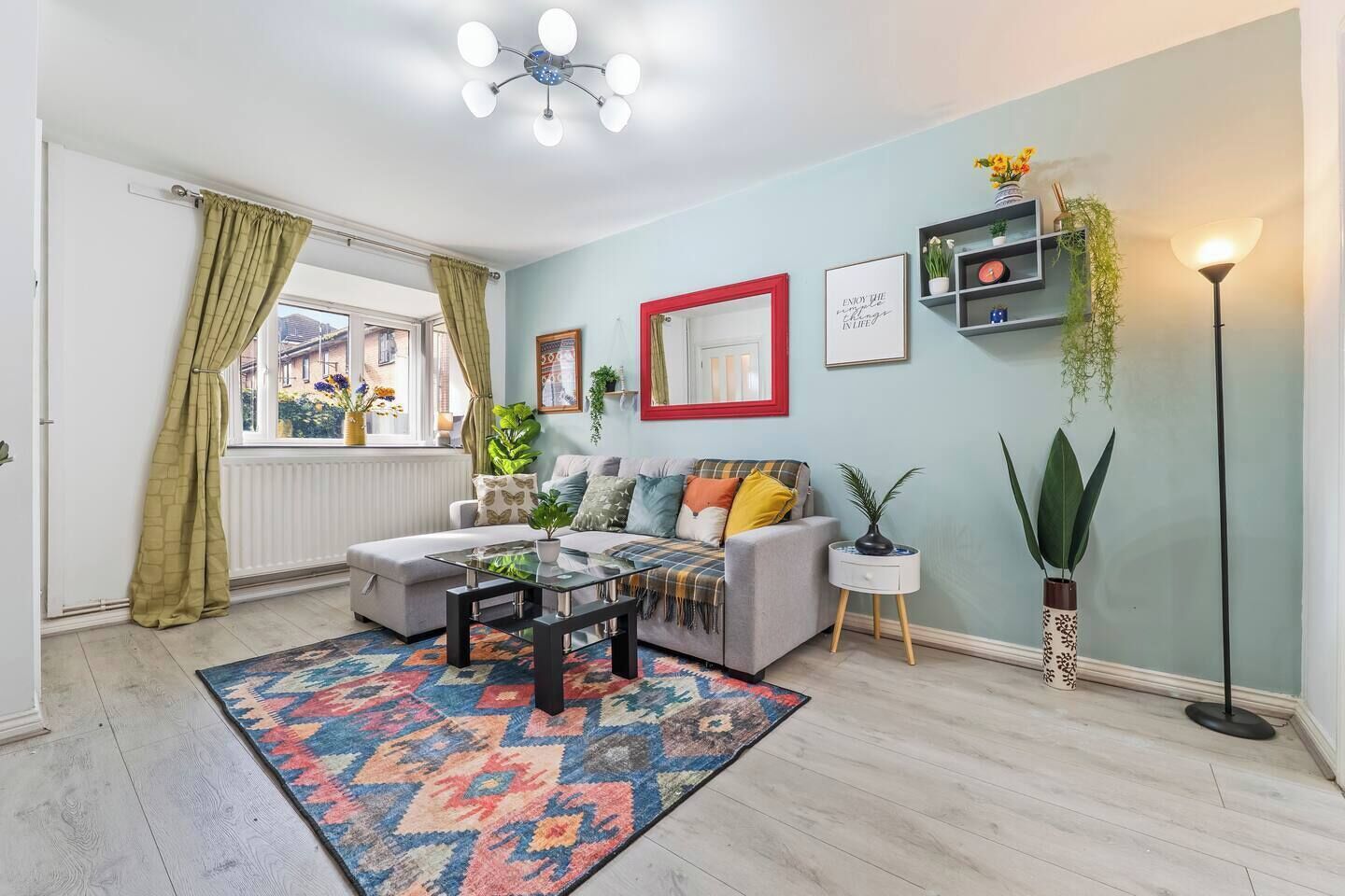 A living room with a sofa, coffee table, patterned rug, and a floor lamp.