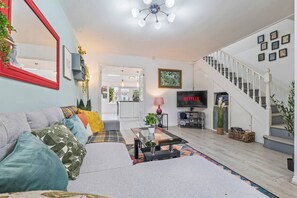 A modern living room with a sofa, coffee table, and a TV displaying 'NETFLIX'. - #126 Cosy 5 mins to Coventry Cathedral | sleeps 7 (West Midlands)