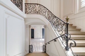 A grand staircase with ornate black metal railings and a checkered floor pattern. - L'Escale Rémoise - À 600 m de la Porte de Mars (Reims)