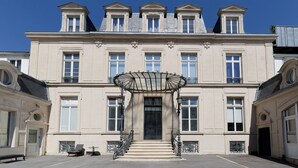A large, classical building with a symmetrical facade, multiple windows, and a central entrance with a decorative canopy. - L'Escale Rémoise - À 600 m de la Porte de Mars (Reims)