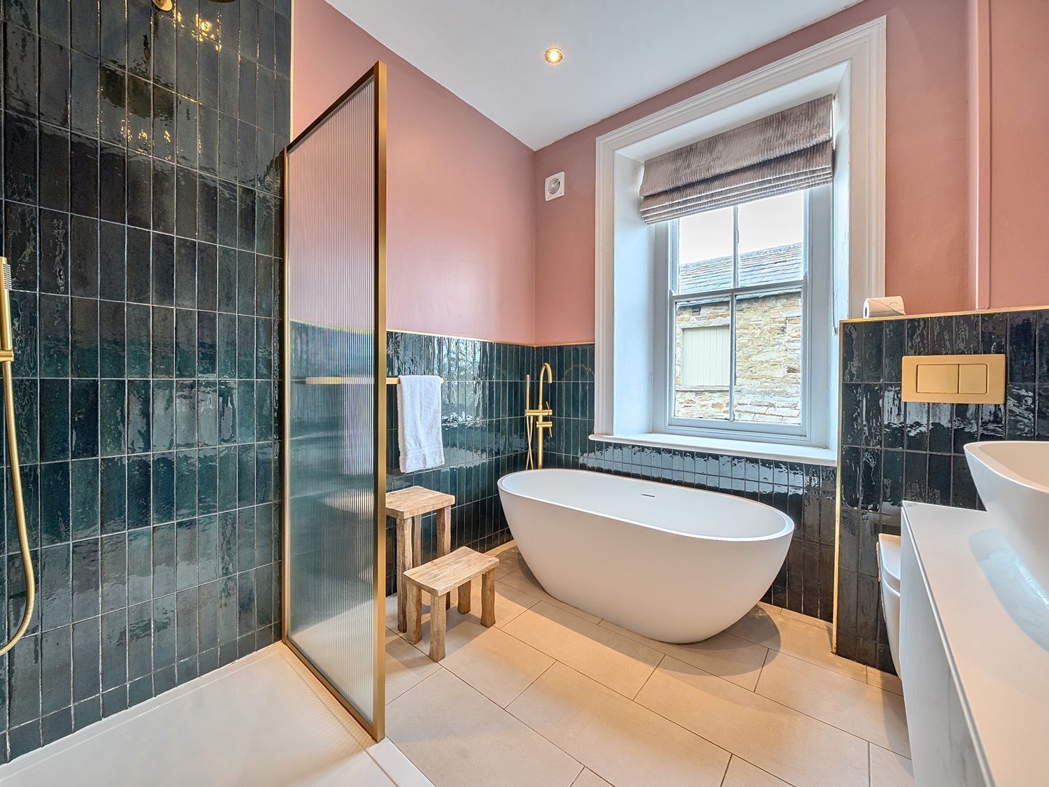 Un baño moderno con una bañera independiente, una cabina de ducha de vidrio y un ventanal con vistas.