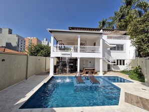 A two-story house with a swimming pool, a waterfall feature, and a patio with outdoor furniture. - Lake Mansion, exclusive suite, full range of recreational facilities (São Paulo)