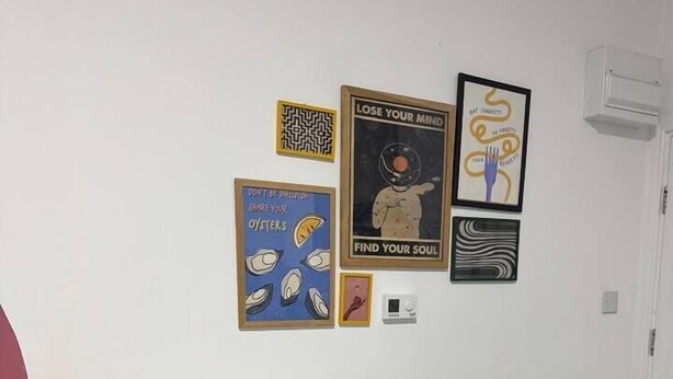 A small room with a white desk, a black chair, and a lamp. There are four framed posters on the wall. - #127 Modern City Suite | Digbeth Creative Quarter (West Midlands)