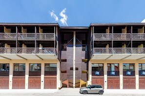 A two-story building with balconies, wooden doors, and a car parked in front. - Chez Joséphine - Station de ski accessible à pied (Gresse-en-Vercors)