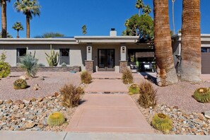 A modern house with a paved driveway, surrounded by desert plants and palm trees. - Palm Springs Retreat-Come and relax. (Palm Springs)