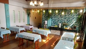 Ein Essbereich mit mehreren Tischen, Stühlen und einer Theke mit dekorativem Hintergrund.