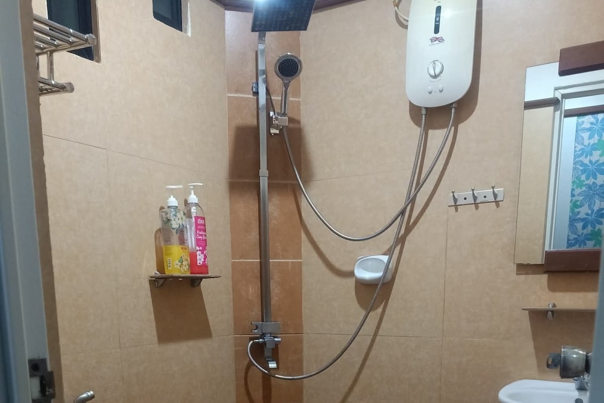 A bathroom with a shower, toilet, and sink.