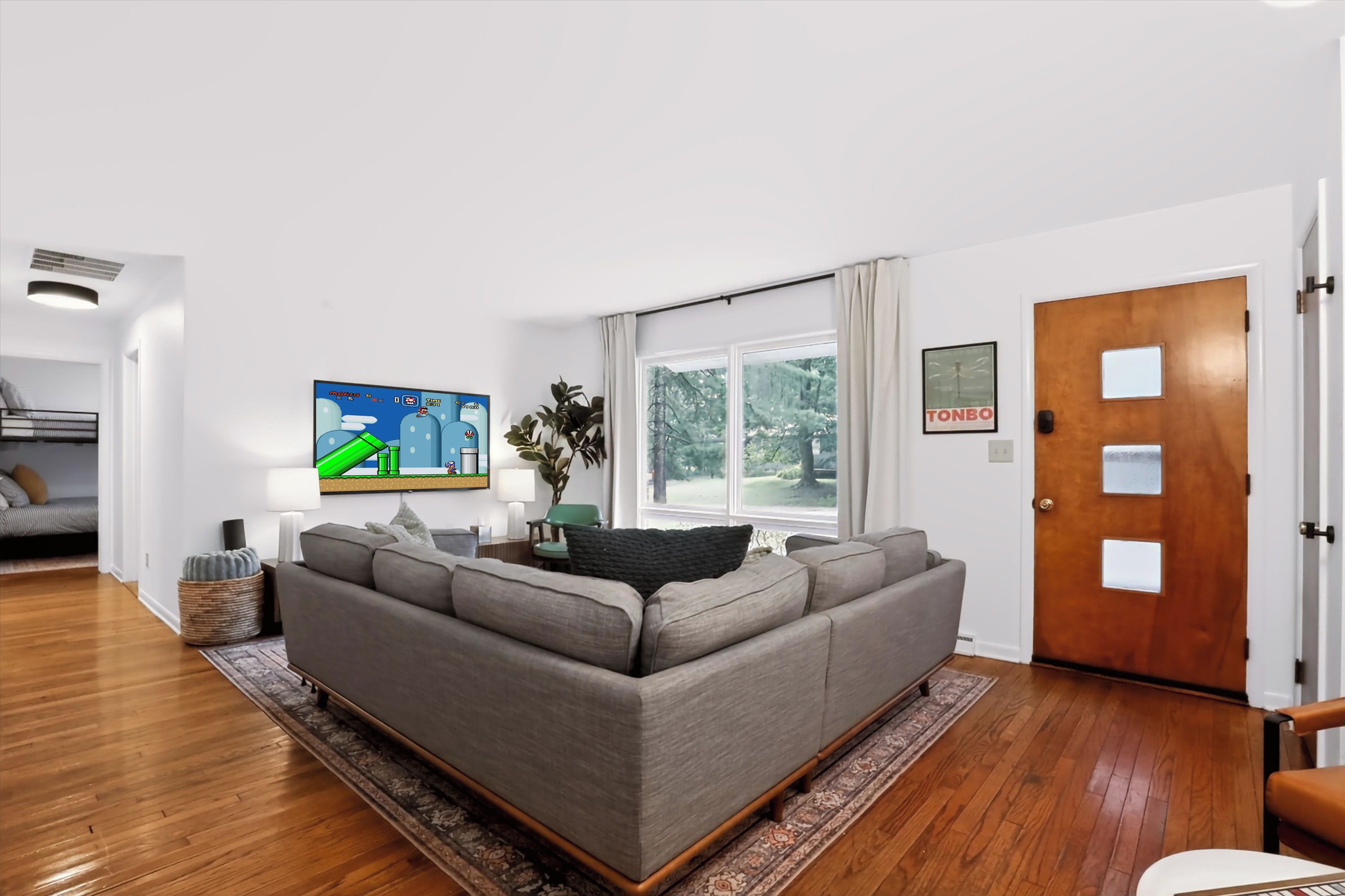 Comfy, cozy living room complete with 65" television and Super Nintendo console.