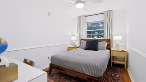 A bedroom with a bed, a nightstand, a lamp, a globe, and a ceiling fan. - Close to campus. Awesome hangout home! (Bloomington)