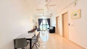 A modern hotel room with a dining area, a ceiling fan, and a view of the cityscape. - Trion KL Residence Pearl Suites (Kuala Lumpur)