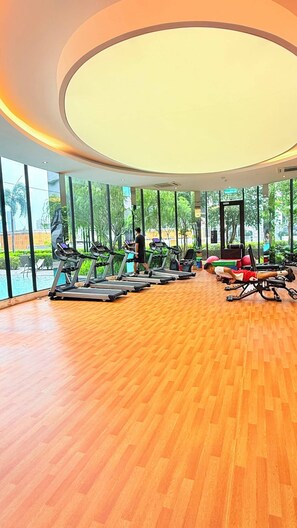 A spacious gym with multiple treadmills, a rowing machine, and a bench press area. - Trion KL Residence Pearl Suites (Kuala Lumpur)