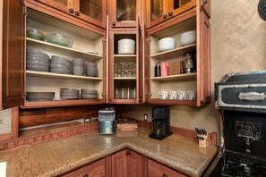 A kitchen with wooden cabinets, a granite countertop, and a stove.