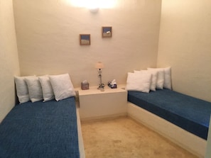 A small room with two single beds, a bedside table with a lamp, and two framed pictures on the wall. - Zephyros | Pool & Tennis (Koundouros)