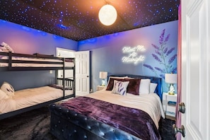 A bedroom with bunk beds, a bed with a purple velvet cover, a wall with a 'Meet Me At Midnight' sign, and a starry ceiling. - Swiftie Suite on Music Row | 2BR 2BA | Sleeps 6 (Nashville)