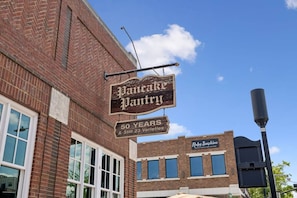 Un bâtiment en briques sur lequel est apposée une enseigne indiquant « Pancake Pantry », mentionnant 50 ans d’activité et 23 variétés de crêpes.