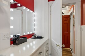 A room with a vanity mirror, lights, and a red door. - Elvis`s Heartbreak Hotel on Music Row - Sleeps 6 (Nashville)