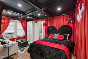 A bedroom with a large bed, red curtains, a wardrobe, and a neon sign. - Elvis`s Heartbreak Hotel on Music Row - Sleeps 6 (Nashville)