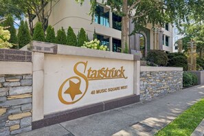 L’entrée d’un immeuble, avec une enseigne indiquant « Starstruck 40 Music Square West » et un mur en pierre.