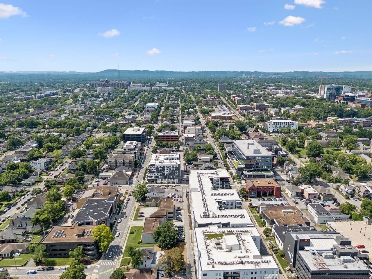 Une vue aérienne d’une ville, avec un mélange de bâtiments résidentiels et commerciaux, de routes et d’espaces verts.