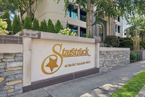 Entrada de um edifício com uma placa indicando 'Starstruck 40 Music Square West' e uma parede de pedra.