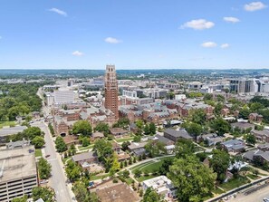 An aerial view of a cityscape with a prominent tower, residential areas, and a mix of commercial buildings. - Backwoods Barbie Suite | Sleeps 10 on Music Row (Nashville)