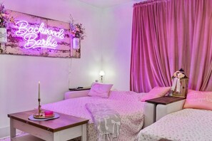 A bedroom with a neon sign, pink curtains, and a decorative lantern. - Backwoods Barbie Suite | Sleeps 10 on Music Row (Nashville)