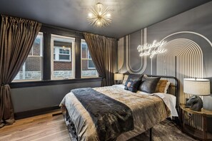 A modern bedroom with a large bed, a neon sign, and a view of the outside. - Tennessee Whiskey Lounge on Music Row - sleeps 6 (Nashville)