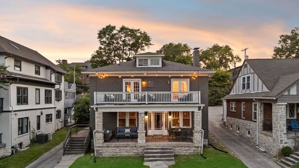 A two-story house with a balcony, a front porch with outdoor seating, and a well-maintained lawn. - Tennessee Whiskey Lounge on Music Row - sleeps 6 (Nashville)