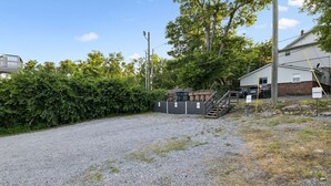 A gravel parking area with a building and a staircase leading to a covered area. - Tennessee Whiskey Lounge on Music Row - sleeps 6 (Nashville)